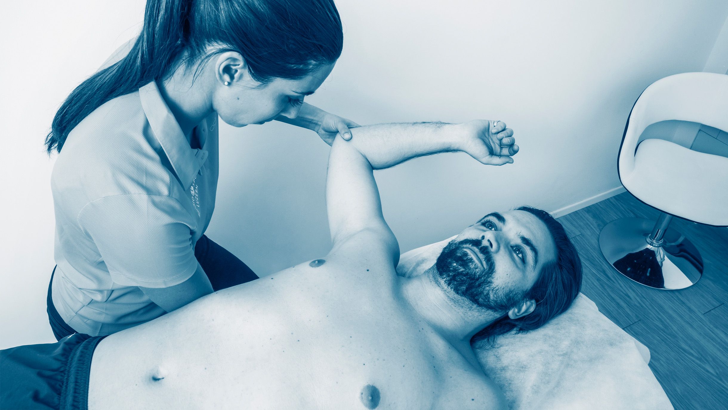 Physiotherapeutin mit Patient bei Schulterbehandlung