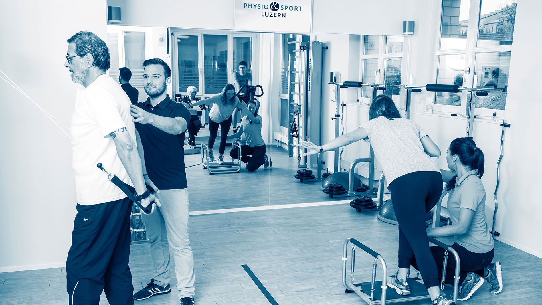 Patienten mit Therapeuten im Physioraum